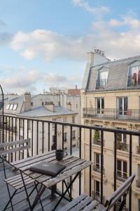巴黎圣路易皮嘉尔酒店的阳台配有桌椅,设有建筑