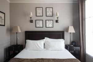 巴黎圣路易皮嘉尔酒店的卧室配有一张墙上三幅照片的床