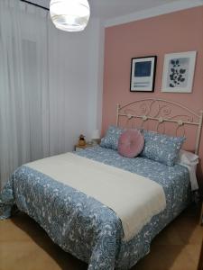 谢拉德埃瓜斯Casa nueva en Urbanización la Biznaga的一间卧室配有一张带粉红色墙壁的大床