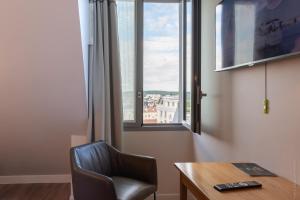 凡尔赛凡尔赛大厦酒店的客房设有椅子、书桌和窗户。