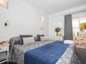 波连萨港辛格拉酒店的一间卧室设有蓝色的床和窗户。