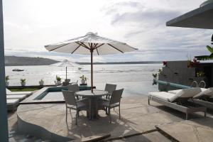 HilibotodaneGrace Wave Resort的庭院配有桌椅和遮阳伞。