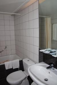 圣尼古拉新佛兰德斯酒店的浴室配有盥洗盆、卫生间和浴缸。