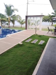 科韦尼亚斯Casa de Playa frente al mar.的庭院设有草地,毗邻游泳池