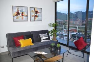 危地马拉Cozy Stays Cayala Apartments 7的客厅配有沙发和桌子