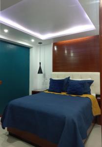 瓦曼特拉La Aurora Hotel Like Home的一间卧室配有蓝色的床和蓝色枕头