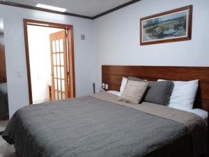 瓦曼特拉La Aurora Hotel Like Home的一间卧室配有一张大床和木制床头板