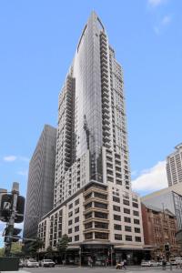 悉尼Meriton Suites Pitt Street, Sydney的一座高大的建筑,侧面有反射