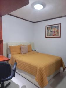 瓦曼特拉La Aurora Hotel Like Home的一间卧室配有一张床、一张桌子和一把椅子