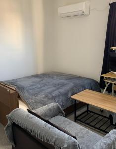 Hukueコンドミニアムホテル　Stay inn Blue room302的客房设有一张床、一张桌子和一张书桌。
