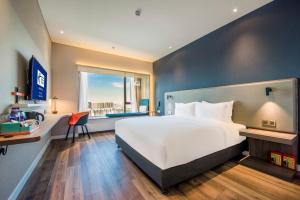 Shunde佛山北滘智选假日酒店的卧室设有一张白色大床和一扇窗户。