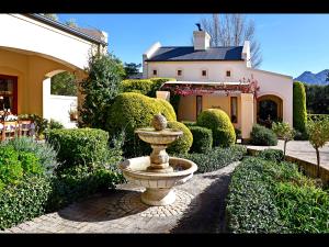 弗朗斯胡克Petit & Grande Plaisir luxury self-catering的花园中的喷泉,在房子前面