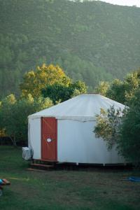 卡亚克Yol Glamping的田野上带红色门的大型白色帐篷