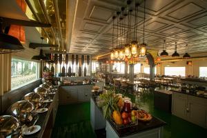 加尔各答Polo Floatel Kolkata的大型用餐室配有桌椅和吊灯。
