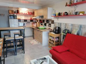 BruyèresChambres d'Hôtes de l'Avison的一间带红色沙发的客厅和一间厨房