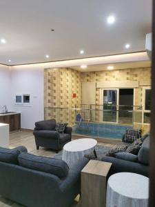 Al RakaPrivate Sand Bond的带沙发和桌子的客厅以及游泳池。