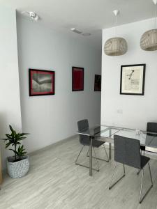 大加那利岛拉斯帕尔马斯Coworking Studio的一间设有玻璃桌和椅子的用餐室
