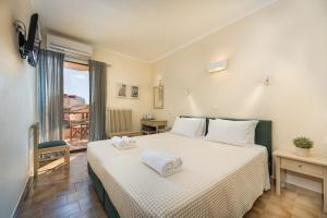 斯卡拉埃雷索Galini Hotel的一间卧室配有一张床,上面有两条毛巾