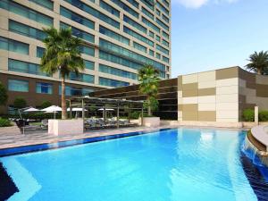 迪拜迪拜古赖尔瑞士酒店的大楼前的大型游泳池