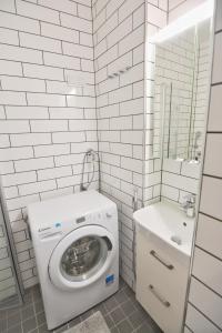 赫尔辛基HOMELY - City Apartment 50m2的白色的浴室设有洗衣机和水槽。