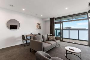 奥克兰Ramada by Wyndham Newmarket Auckland的客厅配有沙发和桌子