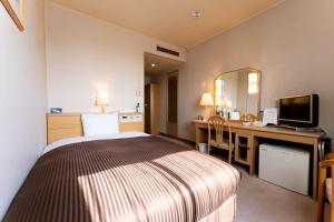 小山市小山宫经济型酒店的配有一张床和一张书桌的酒店客房