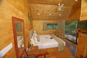 提喀迪Spice Villa Thekkady的木制客房内的一间卧室,配有一张床