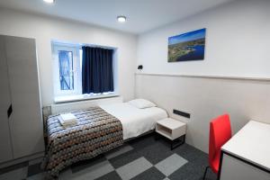 KäärikuKääriku Hotel的酒店客房,配有一张床和一张红色椅子