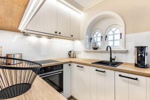 曼克玛肖Ferienhaus Luv的厨房配有白色橱柜和水槽