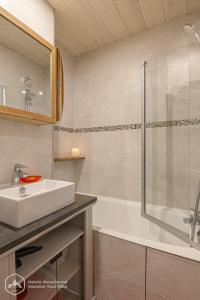 兰斯勒维拉德Le Cocon de l'Arcelle的浴室配有水槽、淋浴和浴缸。