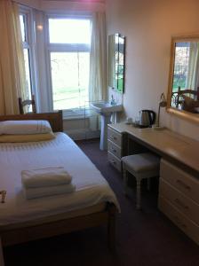 米德尔斯伯勒查德威克旅馆的一间卧室配有一张床、一张桌子和一个水槽