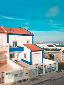 巴勒尔Be Baleal Surfhouse的白色和蓝色的房子设有阳台