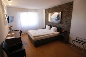 阿尔勒斯海姆艾尔米塔什酒店的一间卧室配有一张床和一把椅子