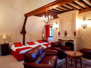 克黑朋Hôtel Le Manoir De Mathan Crépon à la campagne 5 mn d'Arromanches et 10 mn de Bayeux的一间卧室配有一张床、一张沙发和一个壁炉