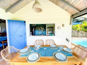 KoolbaaiMoonstone, private room in Villa Casa Blue pool sea view的一张带椅子的木桌和一扇蓝色的门