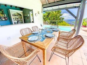 KoolbaaiMoonstone, private room in Villa Casa Blue pool sea view的天井上的木桌和椅子