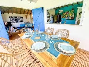 KoolbaaiMoonstone, private room in Villa Casa Blue pool sea view的餐桌,餐盘和椅子