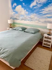 曼德琉-拉纳普勒Appartement lumineux 6 places avec vue sur Marina的一间卧室配有一张带海洋绘画的床