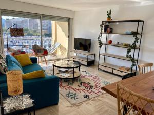 曼德琉-拉纳普勒Appartement lumineux 6 places avec vue sur Marina的客厅配有蓝色的沙发和桌子