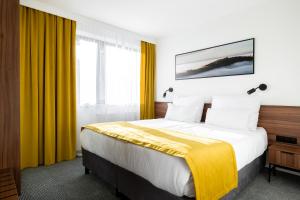 维斯瓦Hotel Vestina的酒店客房,设有一张带黄色窗帘的大床