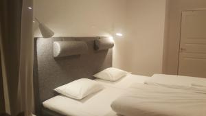 SjötorpSJÖTORPS HOSTEL的卧室配有2张白色的床和1面墙