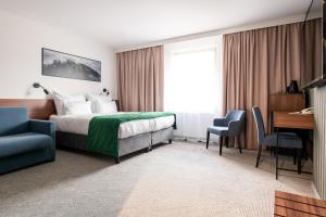 维斯瓦Hotel Vestina的配有一张床和一张书桌的酒店客房