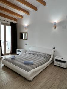 普拉L’ANGELO BIANCO的白色的卧室设有一张大床和一个窗户