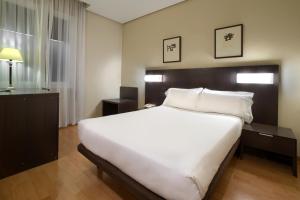 图德拉塞尔科蒂尔图德拉巴德纳斯酒店的卧室配有一张白色大床