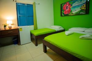 圣安德烈斯Alojamiento San Martín的绿色客房配有两张床和一张书桌