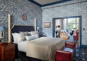牛津The Randolph Hotel, by Graduate Hotels的一间卧室配有蓝色壁纸床