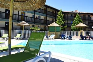 布科·莱斯白老城乐尤卡度假农庄的酒店旁的游泳池配有椅子和遮阳伞