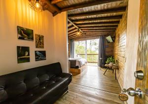 麦德林Cerro Verde Mirador的一间带黑色沙发的客厅和一间卧室