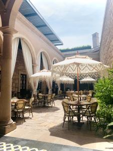 莫雷利亚Casa Vieja Hotel Boutique的一个带桌椅和遮阳伞的户外庭院。