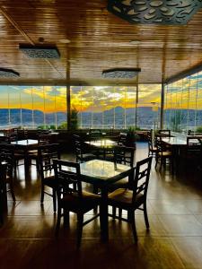 瓦迪穆萨佩特拉埃斯佩兰萨住宿加早餐旅馆的餐厅设有桌椅,享有日落美景。